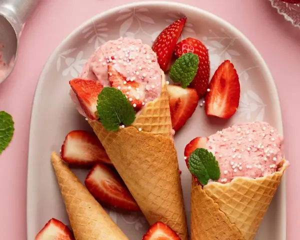 Glace à la fraise maison, facile recette sans sorbetière. Cônes garnis de boules roses, fraises fraîches et menthe.