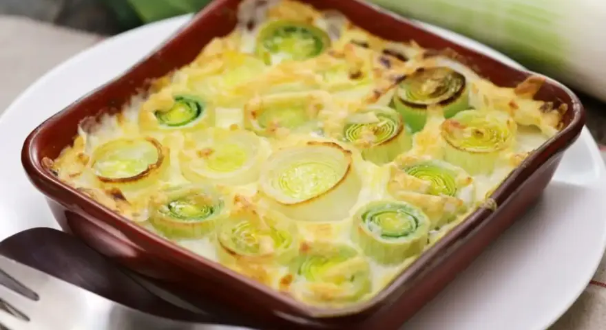 Un délicieux gratin de poireaux crémeux, prêt à être dégusté. Les poireaux coupés en rondelles sont nappés d'une sauce onctueuse et gratinés à la perfection.