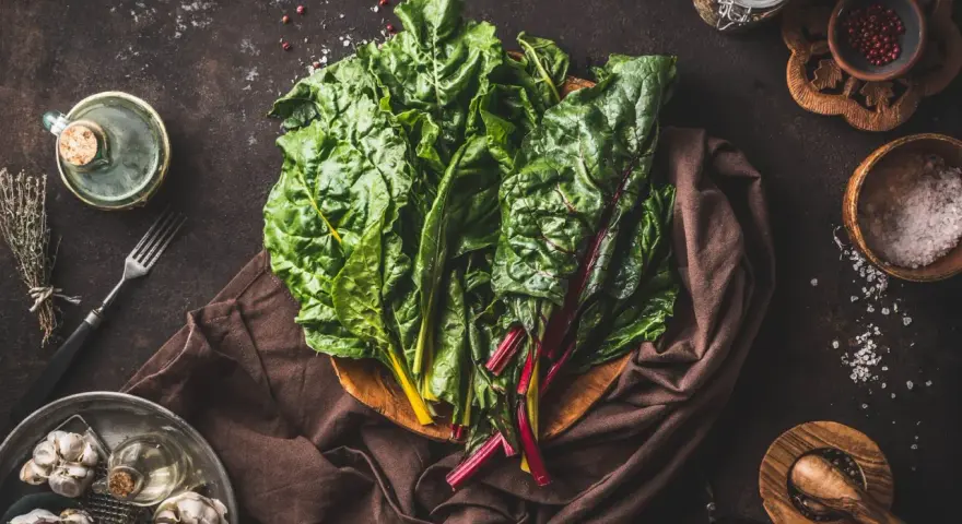 Blettes fraîches, ail, herbes et épices pour une délicieuse recette blette. Huile d'olive et sel complètent les ingrédients.