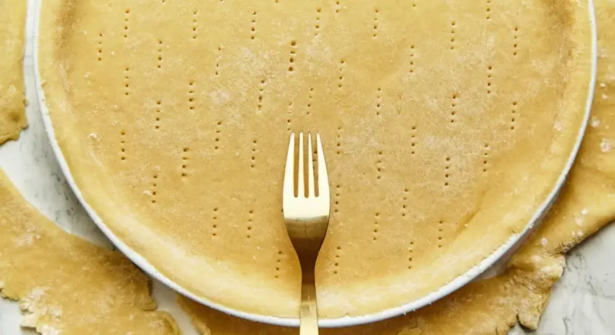 Une pâte brisée sans beurre, piquée à la fourchette, prête à être garnie.