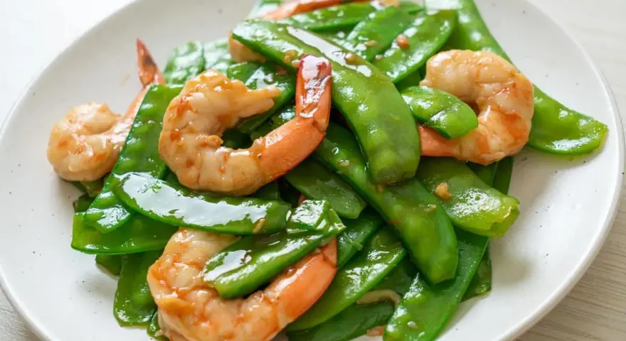 Crevettes sautées avec pois gourmand croquants, un plat coloré et savoureux.