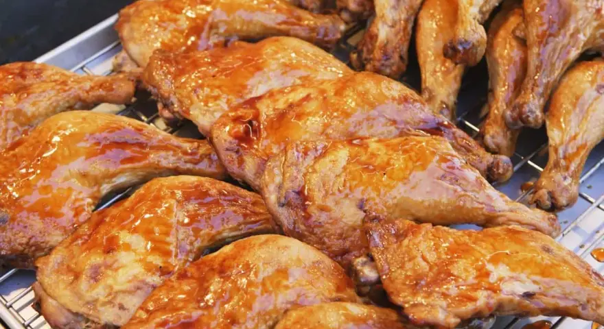 Une belle rangée de pilons de poulet rôtis, brillants d'une sauce caramélisée, prêts à être dégustés.