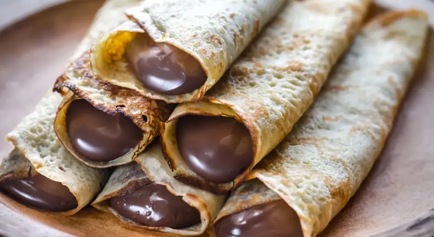 Crêpes roulées généreusement garnies de chocolat fondant. Une idée garniture crêpe sucrée irrésistible pour un goûter gourmand.