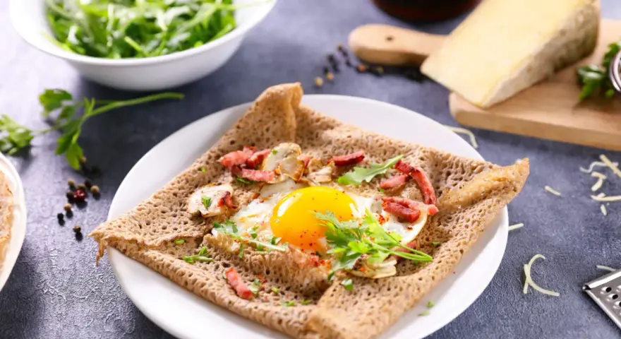 Une galette de sarrasin garnie d'un œuf au plat, de lardons et de champignons. Un délice pour un petit-déjeuner ou un brunch.