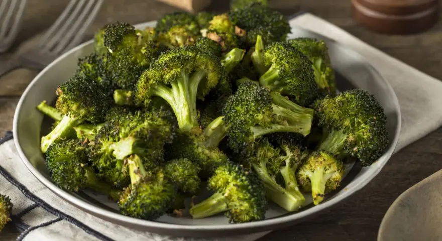 Un plat de brocolis au four, tendres et légèrement caramélisés, prêts à être dégustés.