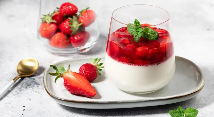Délicieux panna cotta fraise, garni de fruits rouges frais et d'une touche de menthe. Un dessert léger et fruité.