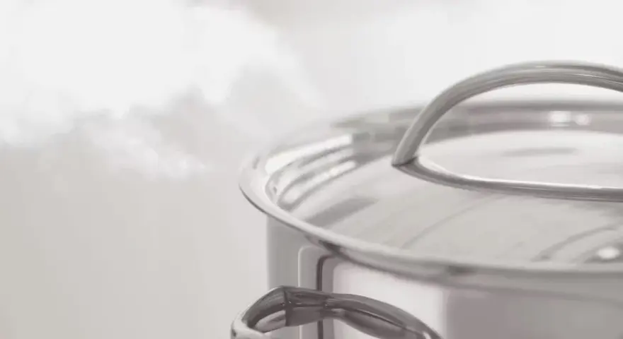 Vapeur s'échappant d'une casserole en inox. Le temps de cuisson du potimarron à l'eau approche de la fin.