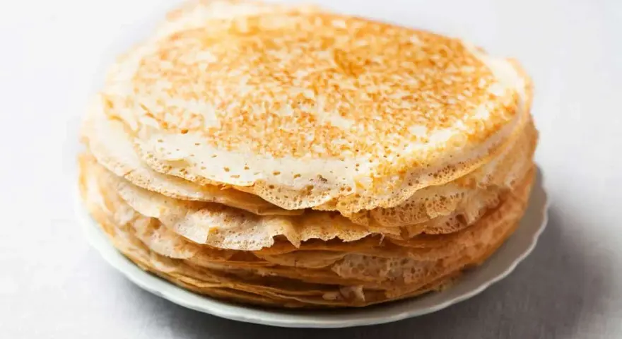 Pile de 10 crêpes sucrées dorées, prêtes à être garnies. Une recette simple pour un plaisir gourmand.