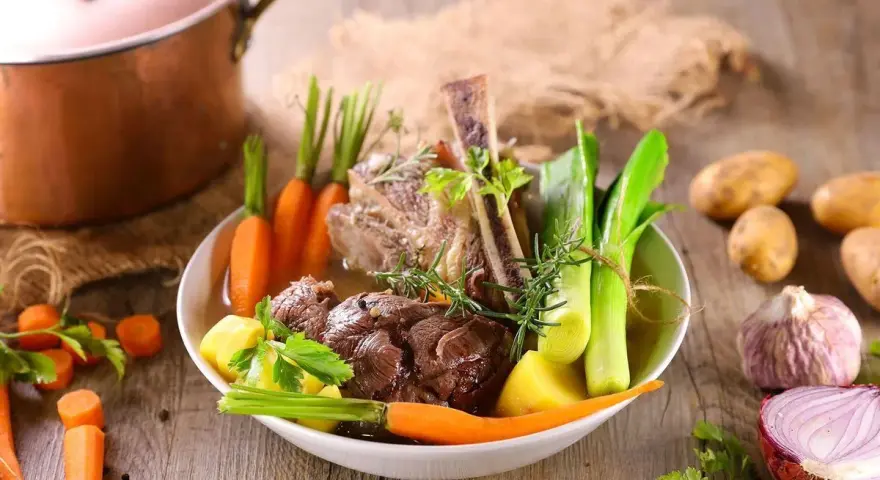 Un plat de pot-au-feu réconfortant avec du bœuf, des carottes, des poireaux et des pommes de terre, prêt à être dégusté.