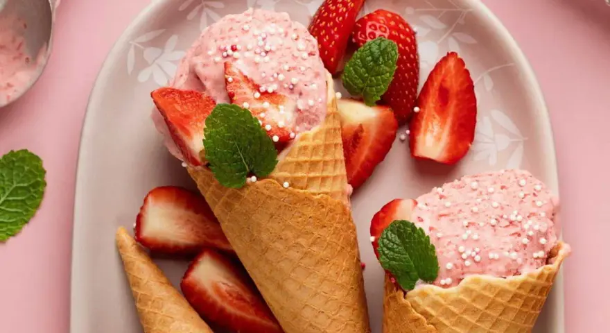 Glace à la fraise maison, facile recette sans sorbetière. Cônes garnis de boules roses, fraises fraîches et menthe.