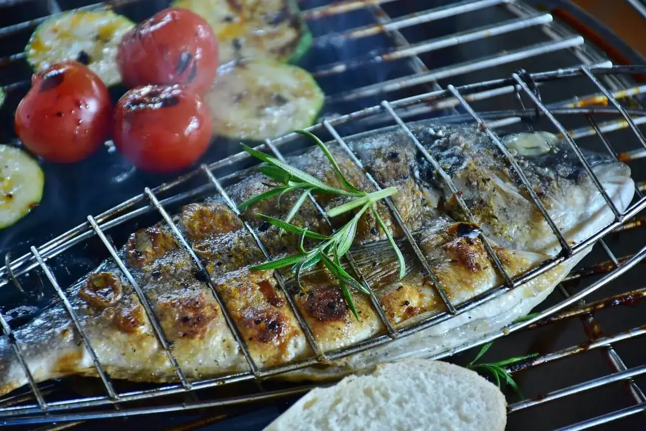 Dorade au barbecue, grill&eacute;e &agrave; la perfection avec des tomates et des courgettes. Une branche de romarin parfume ce plat savoureux.