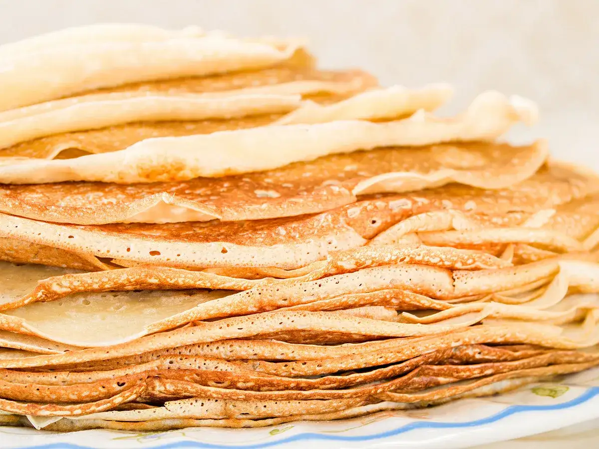 Pile de crêpes dorées. Découvrez par quoi remplacer les œufs dans les crêpes pour une version végétalienne ou sans allergènes.