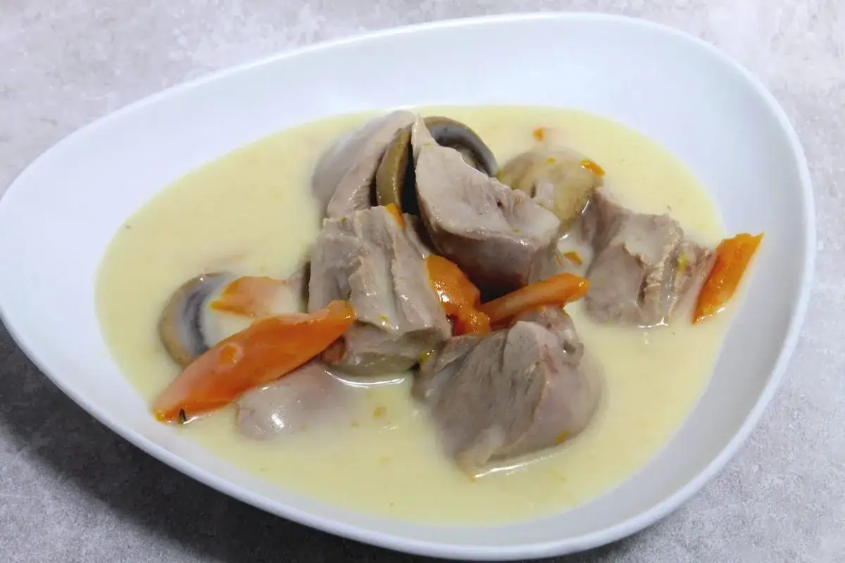 Un plat r&eacute;confortant de blanquette de dinde, avec des morceaux de viande tendre, des carottes et des champignons dans une sauce cr&eacute;meuse.