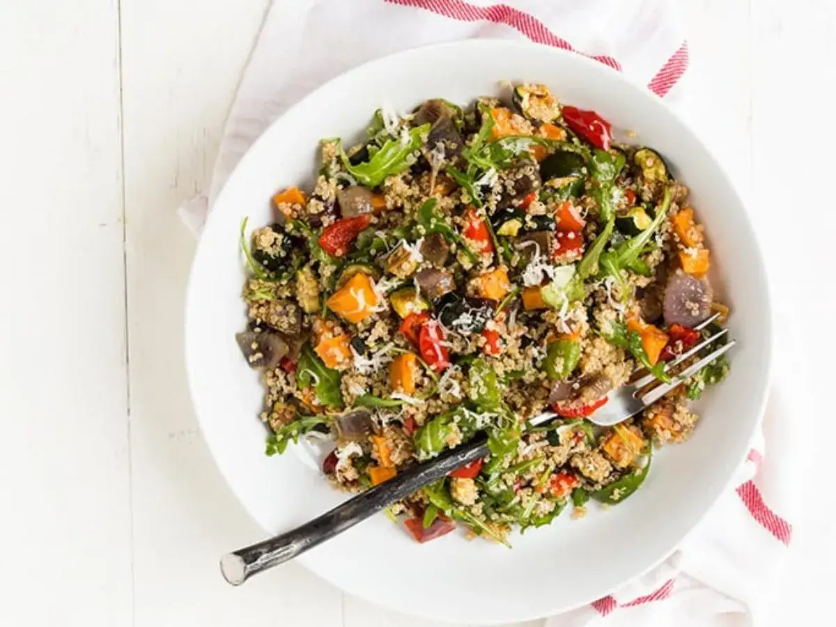 Salade quinoa color&eacute;e avec l&eacute;gumes r&ocirc;tis, roquette et copeaux de parmesan. Un plat sain et savoureux.