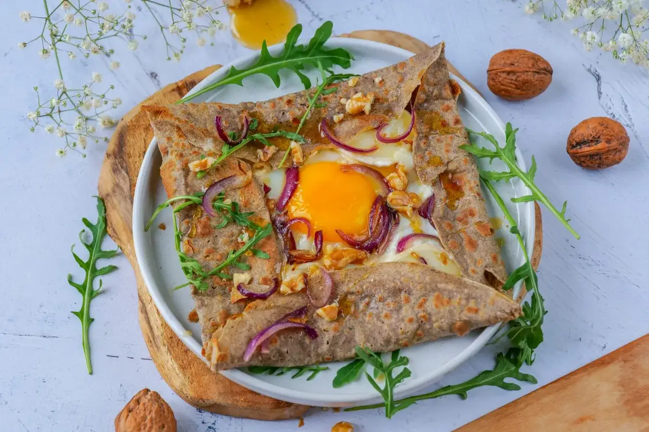 Délicieuse pâte sarrasin garnie d'un œuf coulant, d'oignons rouges, de noix et de roquette. Un délice pour les papilles !