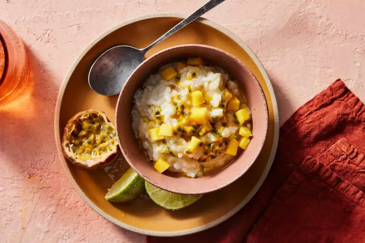 Un d&eacute;liceux dessert lait de coco cr&eacute;meux, garni de mangue et de fruits de la passion, servi avec des quartiers de citron vert.