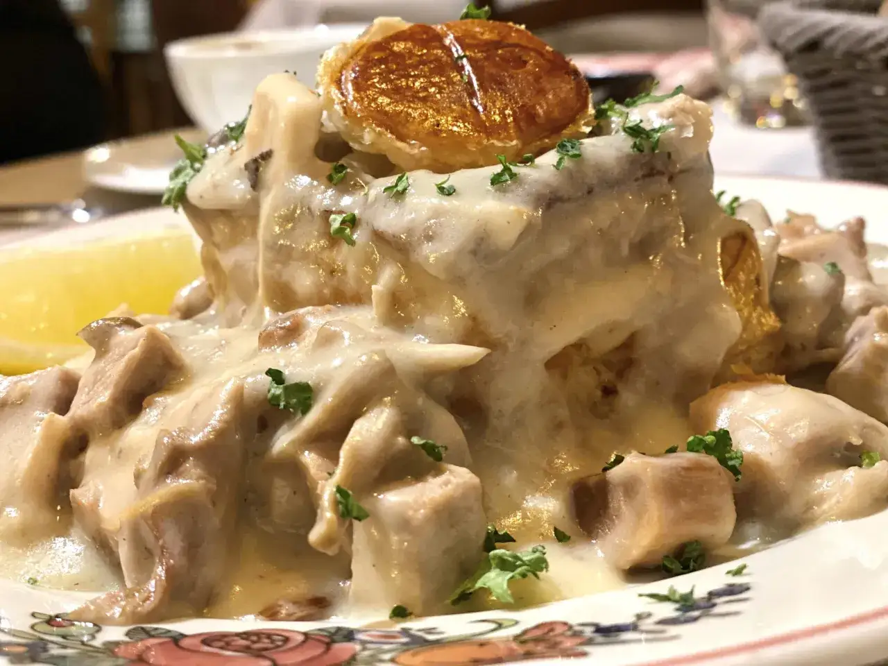 Une g&eacute;n&eacute;reuse bouch&eacute;e &agrave; la reine, napp&eacute;e d'une sauce cr&eacute;meuse et garnie de persil frais, avec un quartier de citron &agrave; c&ocirc;t&eacute;.