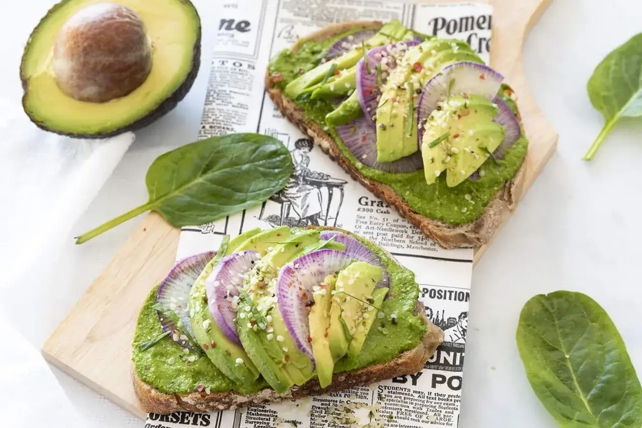 Deux toasts gourmands avec une pur&eacute;e d'avocat, des tranches d'avocat, des radis violets et des graines. Une recette avocat simple et color&eacute;e.