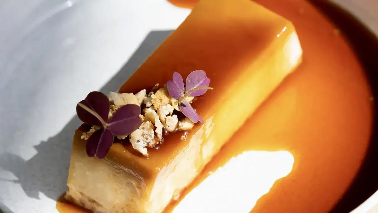 Un d&eacute;licieux cr&egrave;me renvers&eacute;e, napp&eacute; de caramel ambr&eacute;, orn&eacute; de fleurs violettes et de miettes croquantes.