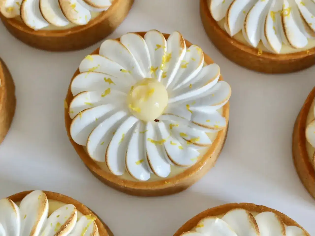 Petites tartelettes au citron meringuées, une recette gourmande avec une crème citronnée et une meringue légère.