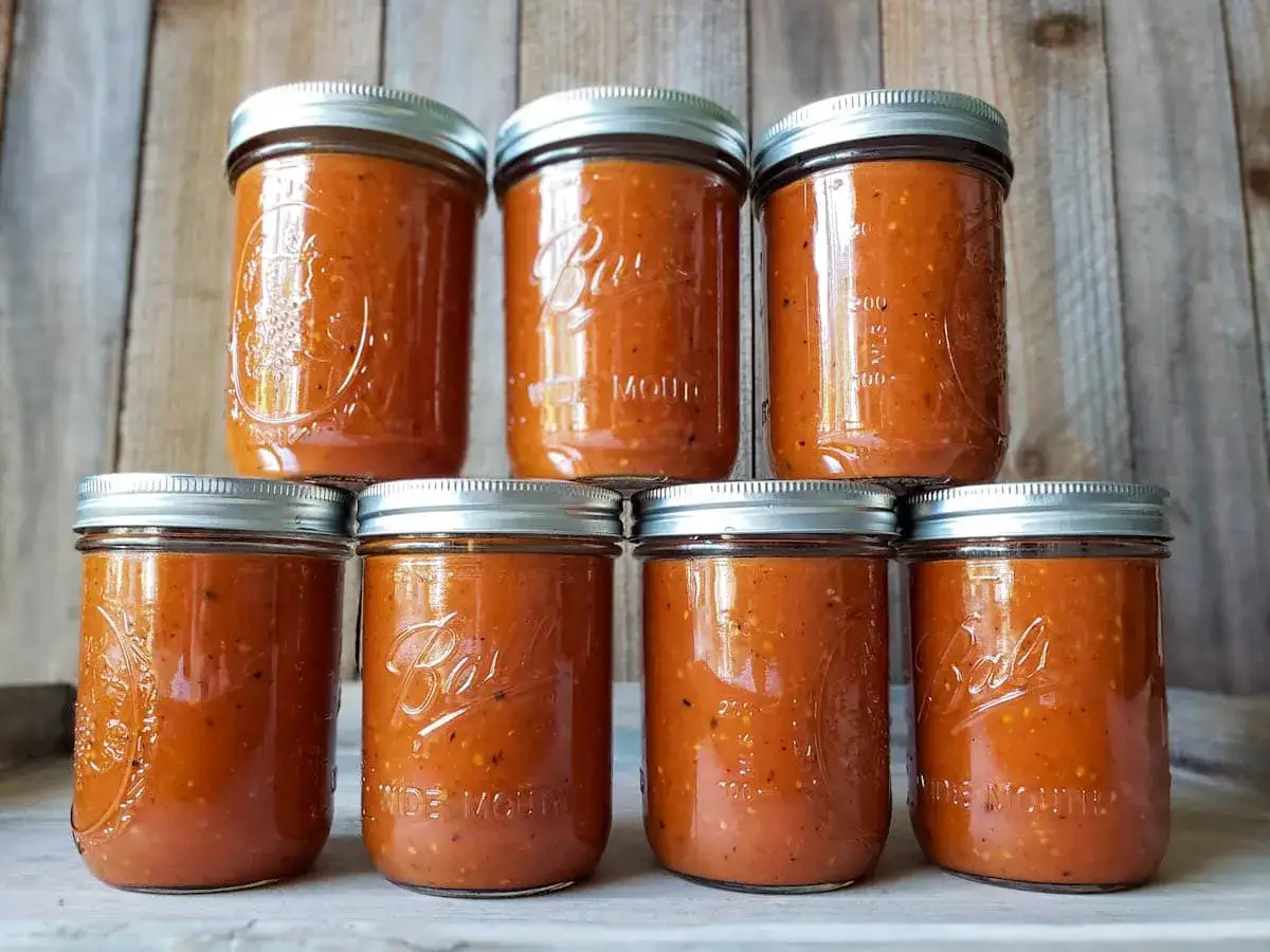 Sept bocaux remplis de coulis de tomates maison, prêts à être dégustés.