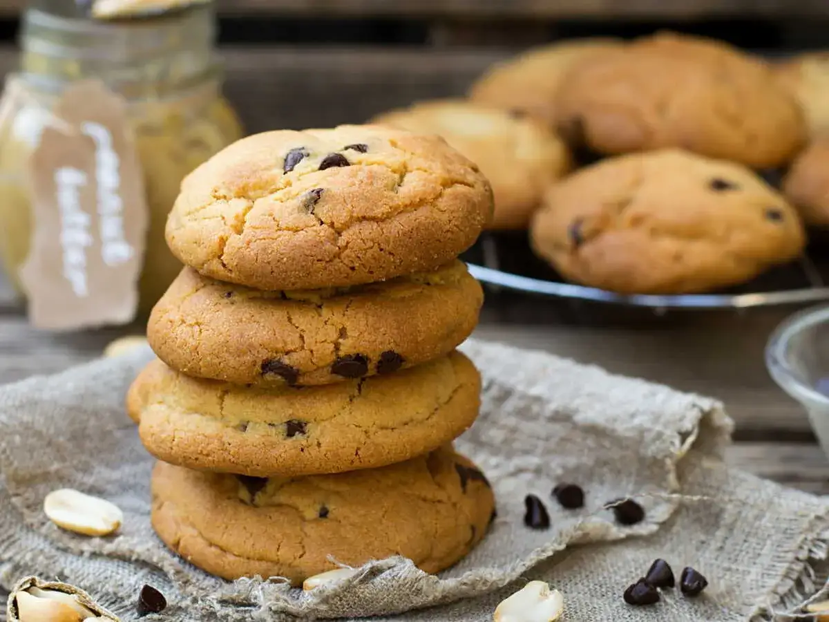 Pile de cookies aux p&eacute;pites de chocolat. Un pot de beurre de cacahu&egrave;te sugg&egrave;re par quoi remplacer le beurre dans les cookies.