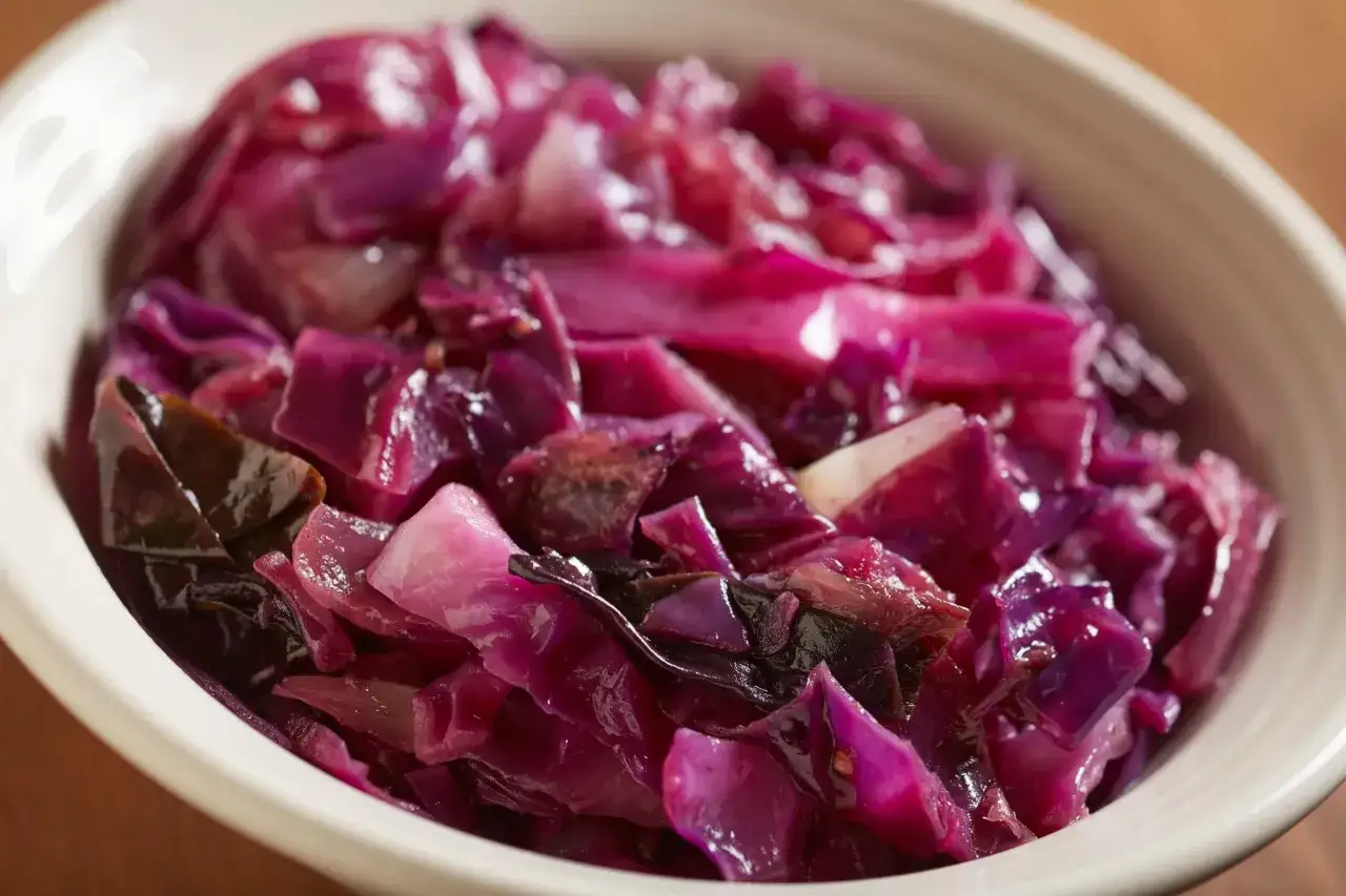 Un plat de chou rouge recette, aux teintes violettes et rosées, servi dans un bol blanc.