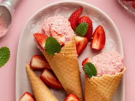 Glace à la fraise maison, facile recette sans sorbetière. Cônes garnis de boules roses, fraises fraîches et menthe.