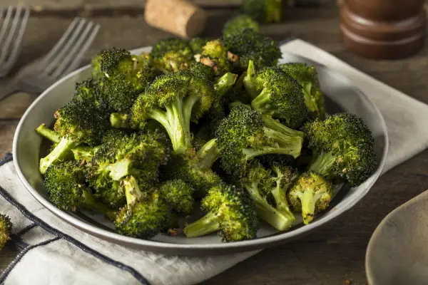 Un plat de brocolis au four, tendres et légèrement caramélisés, prêts à être dégustés.