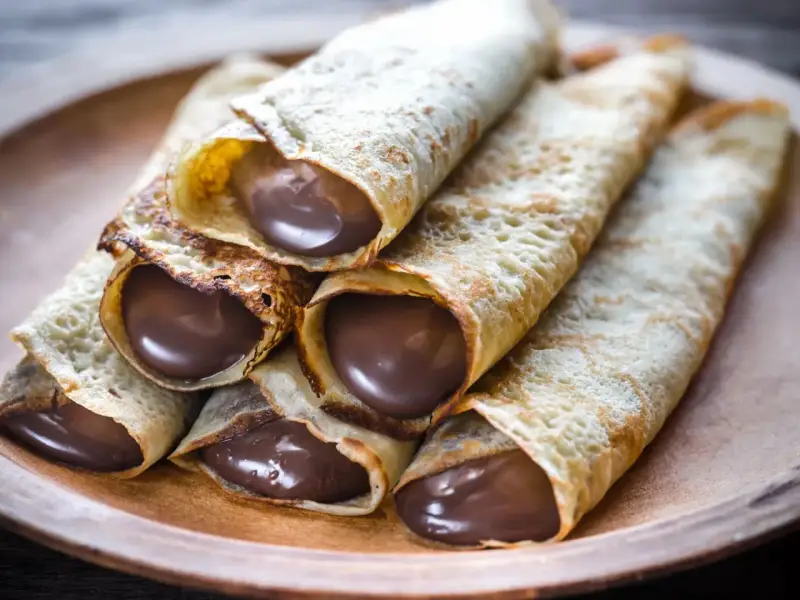 Crêpes roulées généreusement garnies de chocolat fondant. Une idée garniture crêpe sucrée irrésistible pour un goûter gourmand.