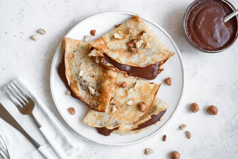 Crêpes garnies de nutella liquide pour crêpe, parsemées de noisettes concassées. Un délice gourmand !